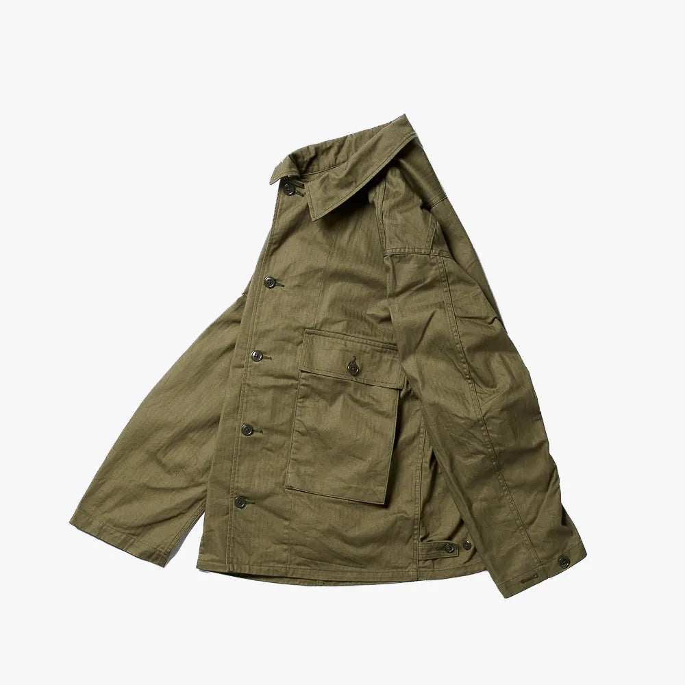 Close-up of the military olive herringbone fabric showing weave texture, durability, and vintage-inspired character.