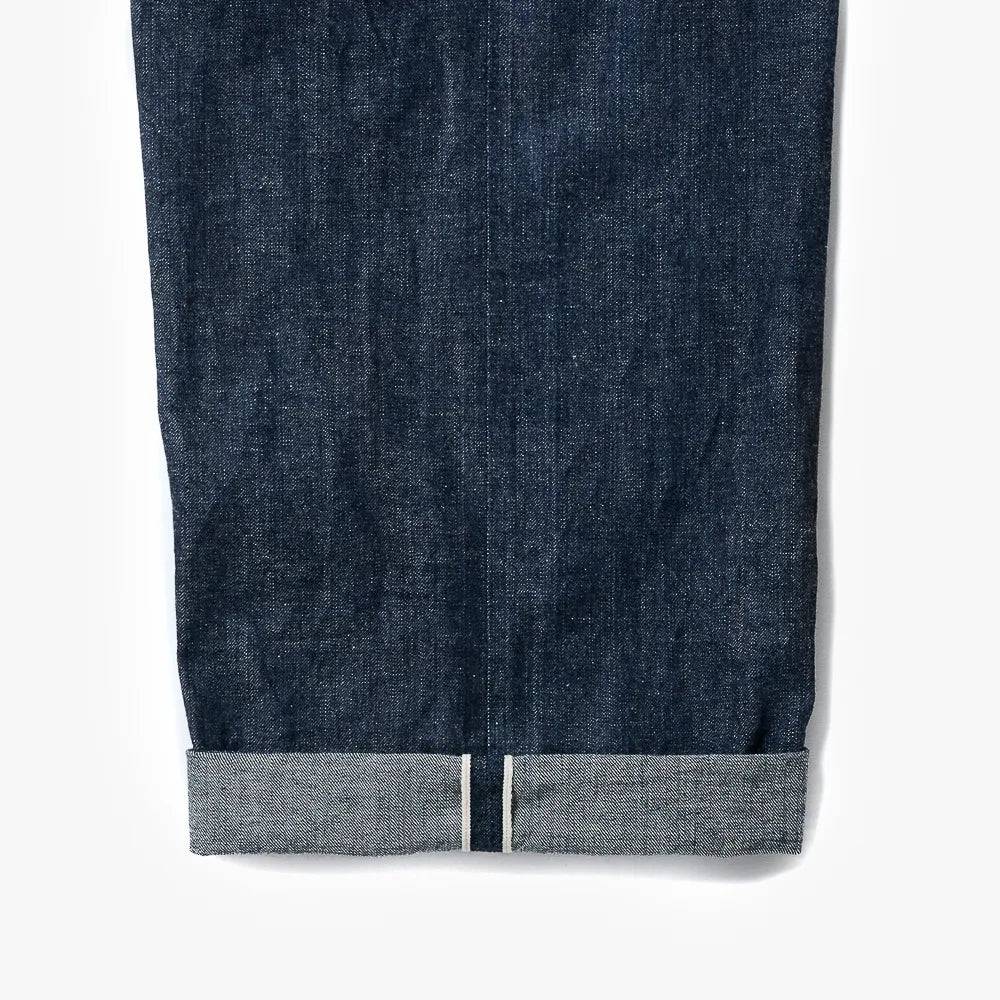 Close-up of the indigo selvedge denim showing the weave texture, depth of color, and selvedge edge detail.