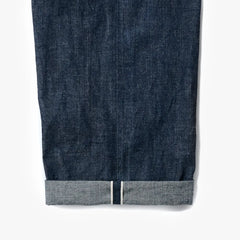 Close-up of the indigo selvedge denim showing the weave texture, depth of color, and selvedge edge detail.