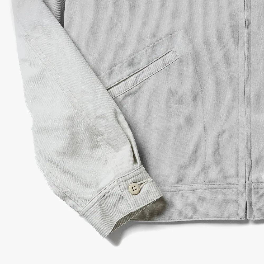 Close-up of the hem and pocket area showing stitching details and the textured weave of the ivory vintage pique fabric.