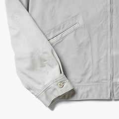 Close-up of the hem and pocket area showing stitching details and the textured weave of the ivory vintage pique fabric.