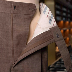 Close-up of the waistband and button area on the Drummers Trousers Beige showing stitching, hardware, and clean finishing.