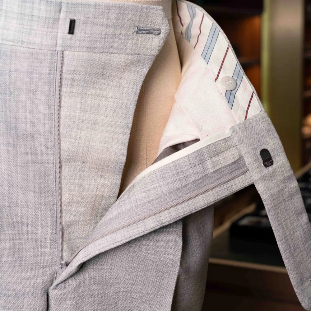 Close-up of the waistband and button area on the Drummers Trousers Light Grey showing stitching, hardware, and construction details.