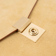 Lock detail of the Frank Clegg 15-inch Lock Portfolio Case Suede Sand/Cognac