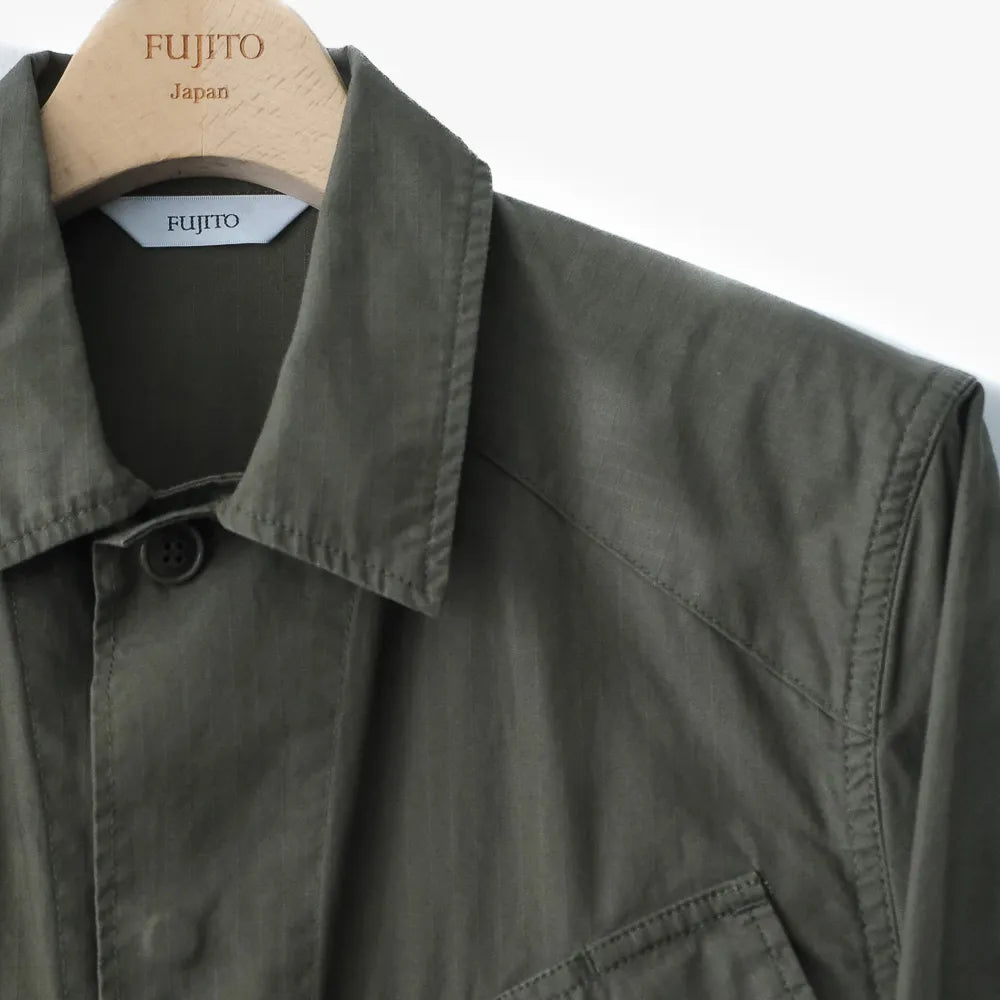 Close-up of the olive green fabric showing texture, weave, and the durable character of the jungle fatigue cloth.