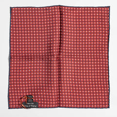 Close-up of the red dot pattern highlighting silk texture and precise weaving detail.