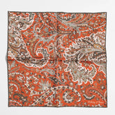 Full view of the Holliday & Brown paisley pocket square in green and brick showing elegant pattern and refined proportions.