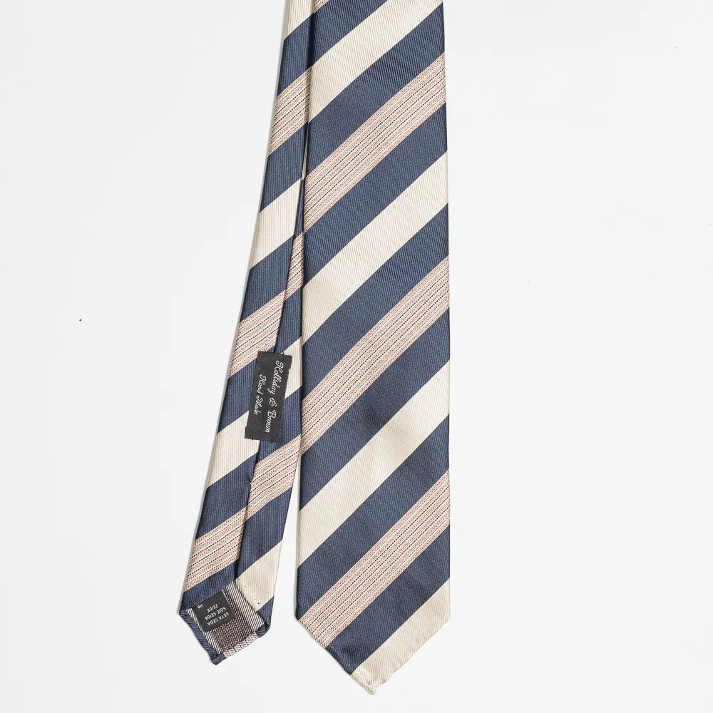 Full view of the Holliday & Brown stripe tie in navy and beige showing classic diagonal stripe pattern and elegant proportions.