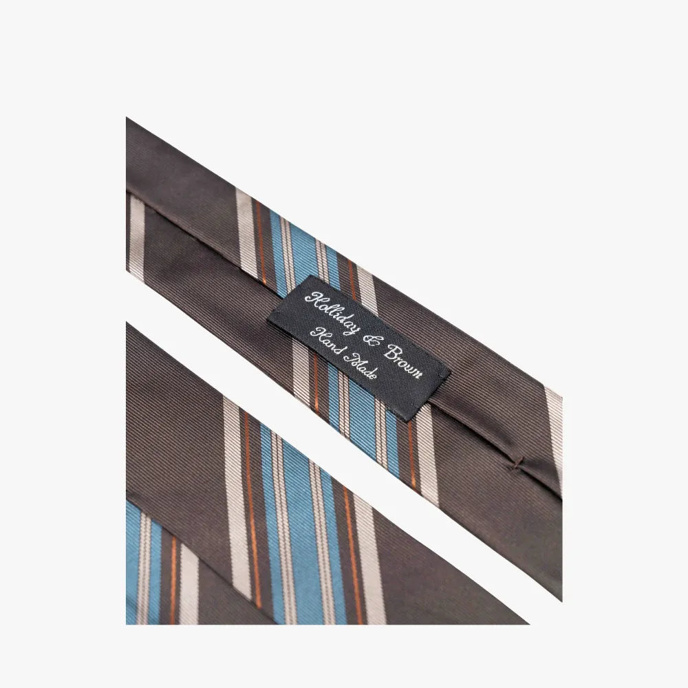 Detailed close-up of the Holliday & Brown Signature Stripe Brown/Blue Tie showing the fabric texture, stripe detailing, and craftsmanship.
