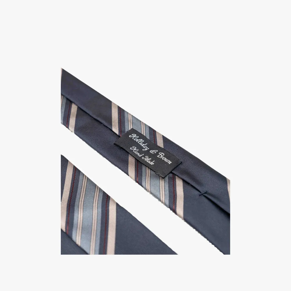 Detailed close-up of the Holliday & Brown Signature Stripe Navy/Blue Tie showing fabric weave, color contrast, and craftsmanship.