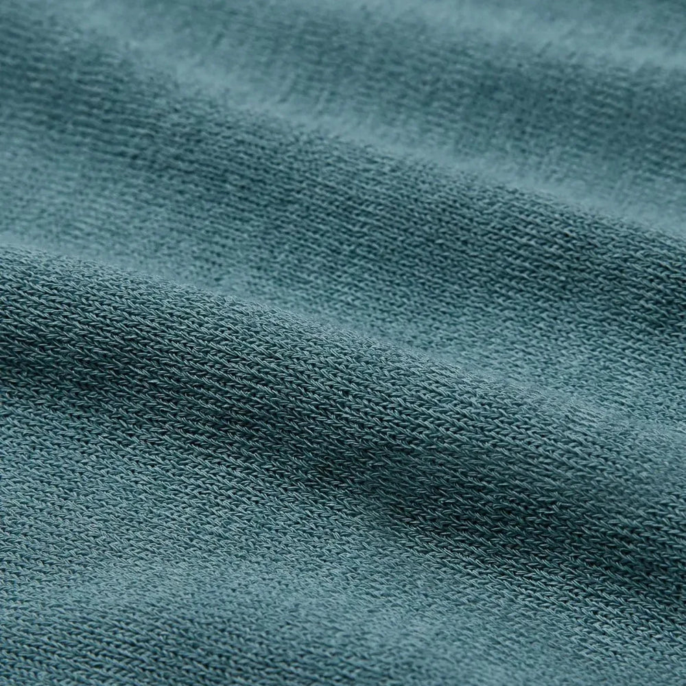 Side view of the Mooncastle Crew Neck Mist Green showing sleeve shape, side seams, and natural knit drape.