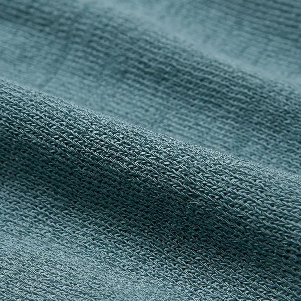 Close-up of the ice cotton knit fabric showing cool-touch yarn texture, tight weave, and gentle mist green color.