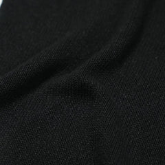 Close-up of the paper-silk blend fabric showing its ultra-light texture, soft handfeel, and matte black appearance.