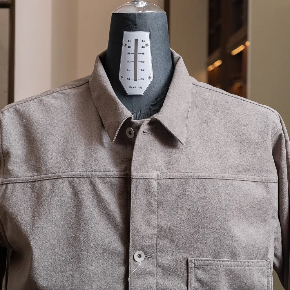 Close-up of the collar and upper chest showing smooth synthetic leather texture and button closure.