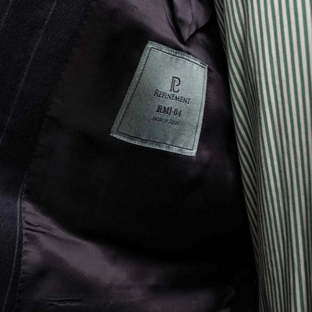 Close-up of the interior labels on the RMJ-04 Chalk Stripe Navy Suit showing Refinement Made By Ring Jacket branding and Ermenegildo Zegna Electa fabric label.