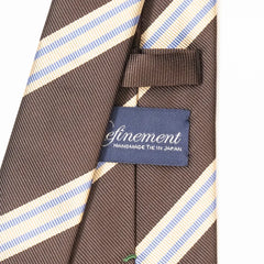 Close-up of the Refinement repp stripe neck tie showing the textured silk weave and brand label detail.
