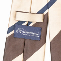 Close-up of the Refinement stripe neck tie showing textured silk weave and brand label detail.