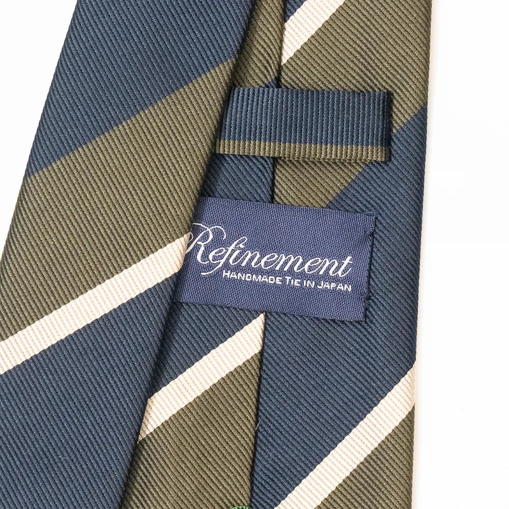 Close-up of the Refinement stripe neck tie showing textured silk weave and brand label detail.