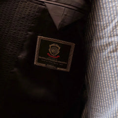 Close-up of the inside label showing Refinement Tailoring branding and Tallia di Delfino cloth tag.