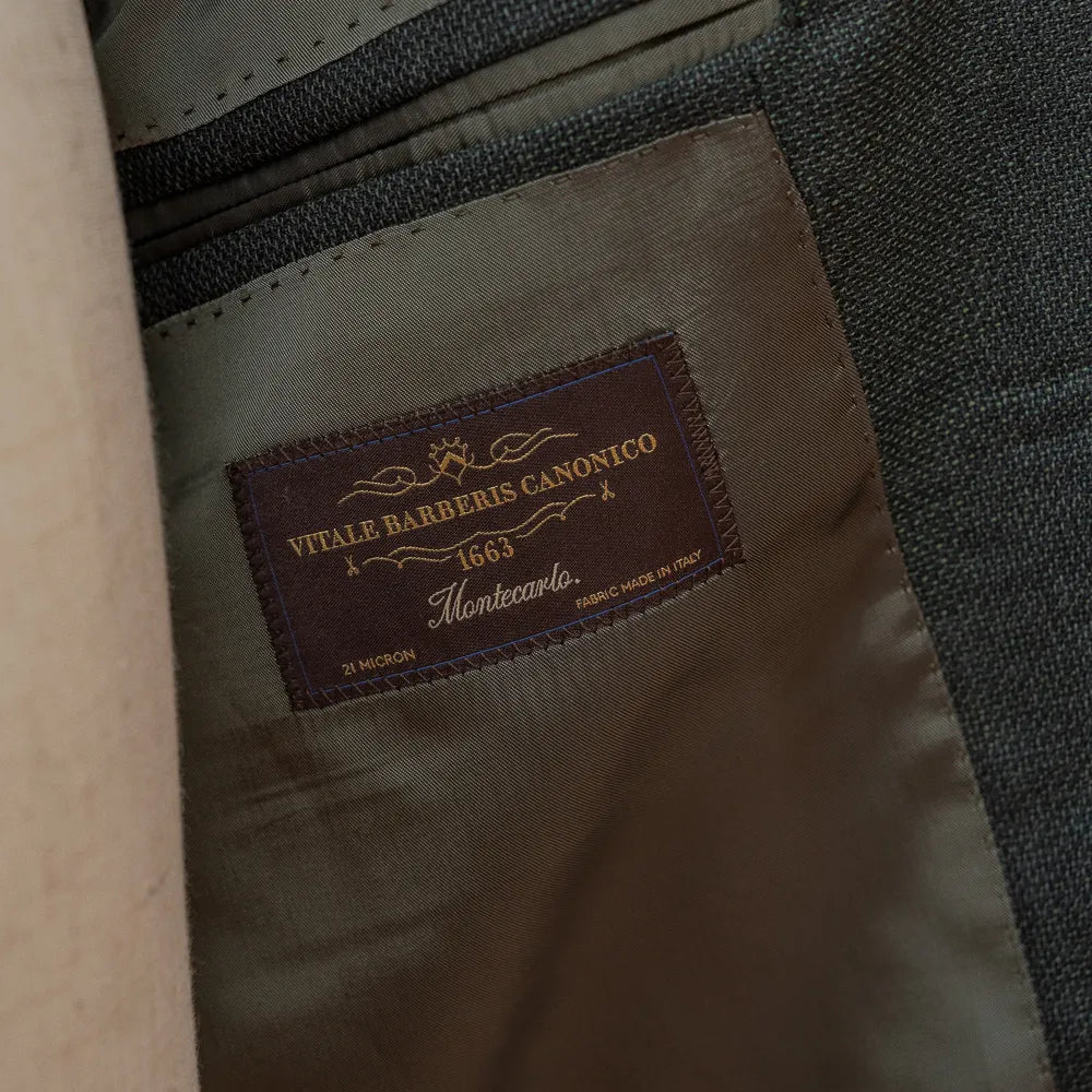 Close-up of the internal label of the RMJ-03 Jacket Green by VBC showing the Refinement × Ring Jacket branding and inner lining construction.