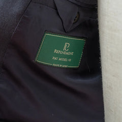 Close-up of the interior labels of the RMJ-03 Navy Suit by Dormeuil showing Refinement × Ring Jacket branding and Dormeuil fabric label.