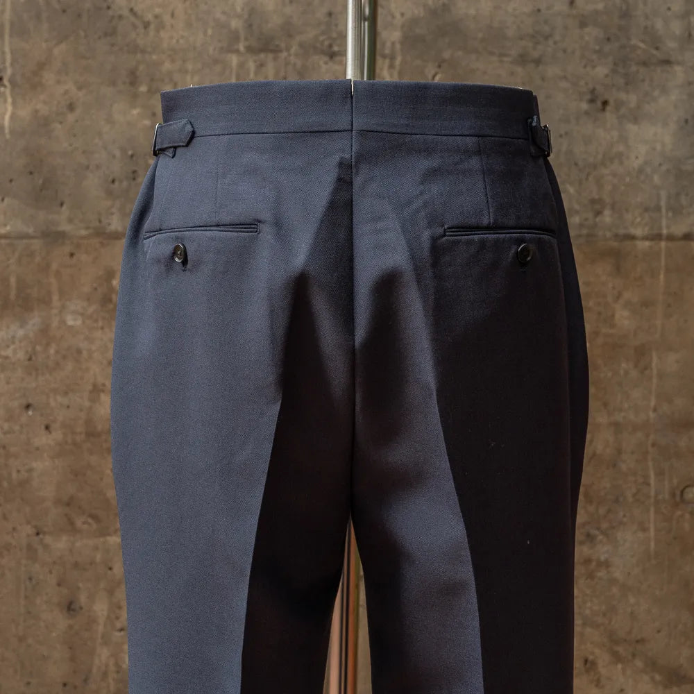 Back view of the trousers from the RMJ-03 Navy Suit by Dormeuil highlighting welt pockets, seam finishing, and structured drape.