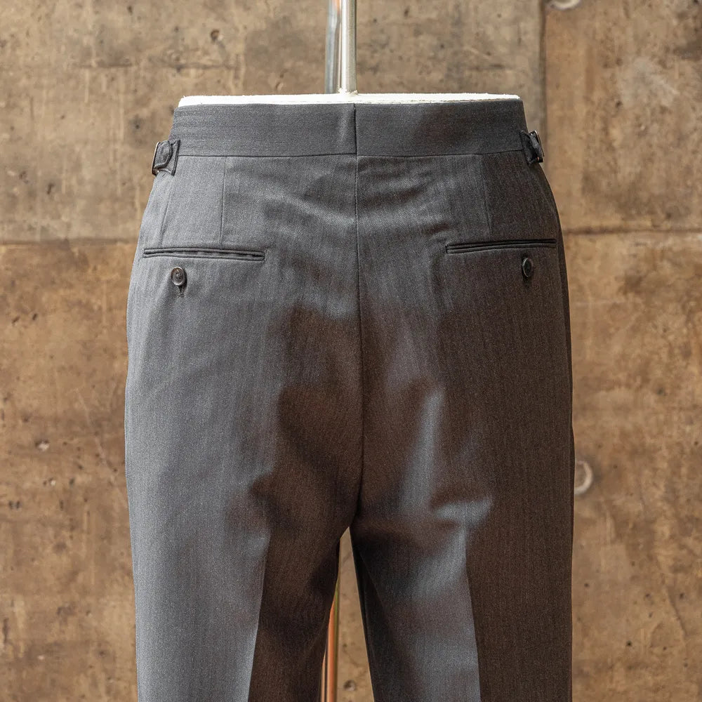 Back view of the trousers highlighting welt pockets, seam finishing, and structured back rise.