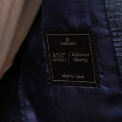 Close-up of the interior label showing Refinement Tailoring branding and Fratelli Tallia di Delfino cloth identification.