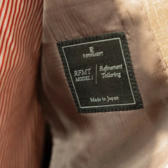 Interior close-up of the Refinement Tailoring brand label showing construction quality and clean finishing.