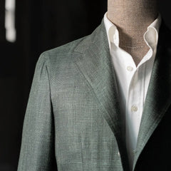 Close-up of the chest area highlighting the lapel roll, welt pocket, and textured green Summertime weave.