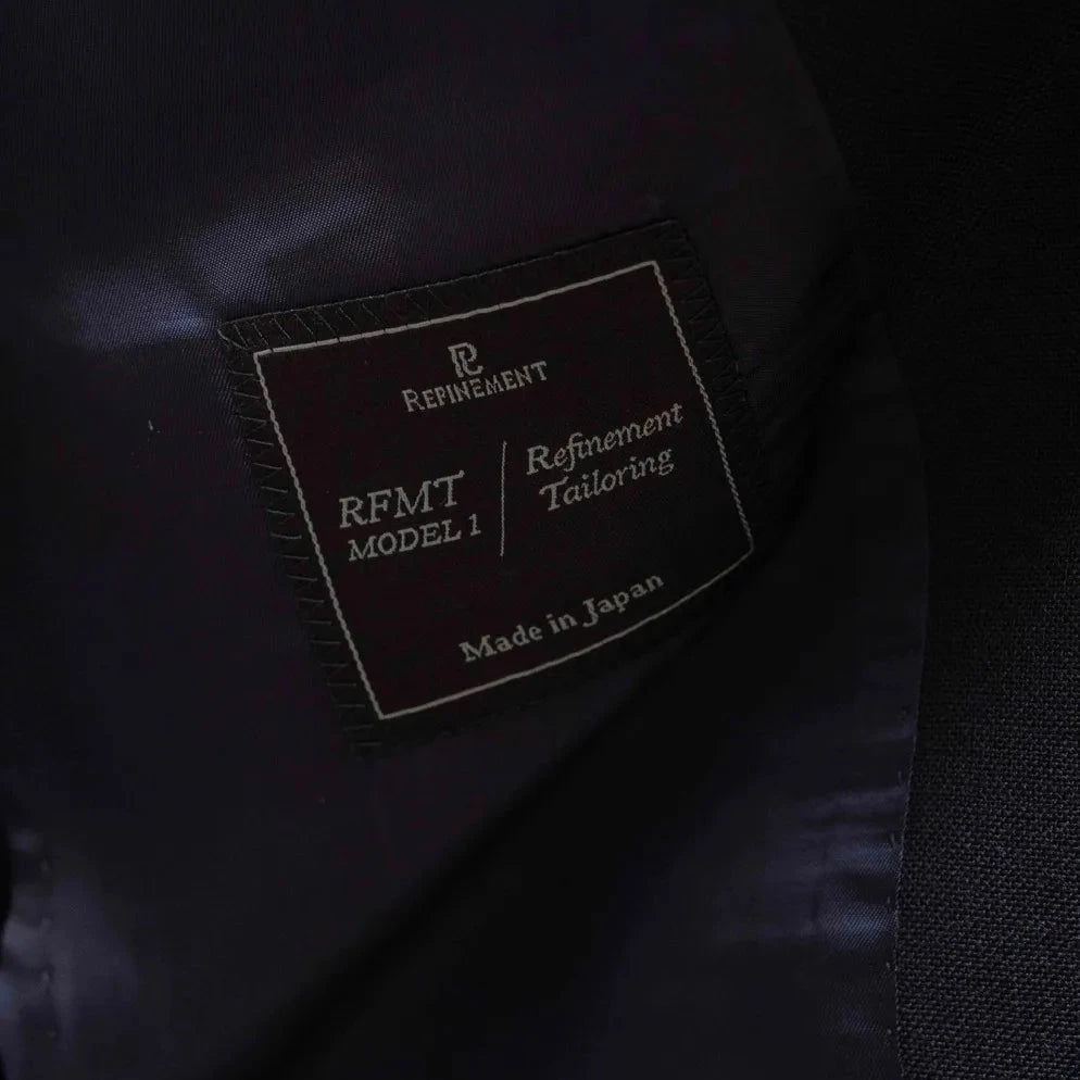 Close-up of the Refinement Tailoring label and Woodhead cloth tag showing craftsmanship.