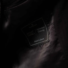 Close-up of the interior label showing Refinement Tailoring branding and Tallia di Delfino cloth identification.