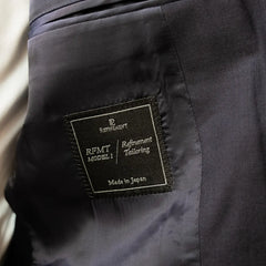 Interior close-up of the Refinement Tailoring brand label showing construction and finishing details.