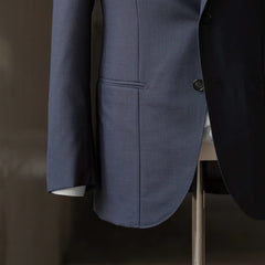 Side detail of the suit jacket highlighting sleeve shape, button stance, and smooth Zelander fabric texture.