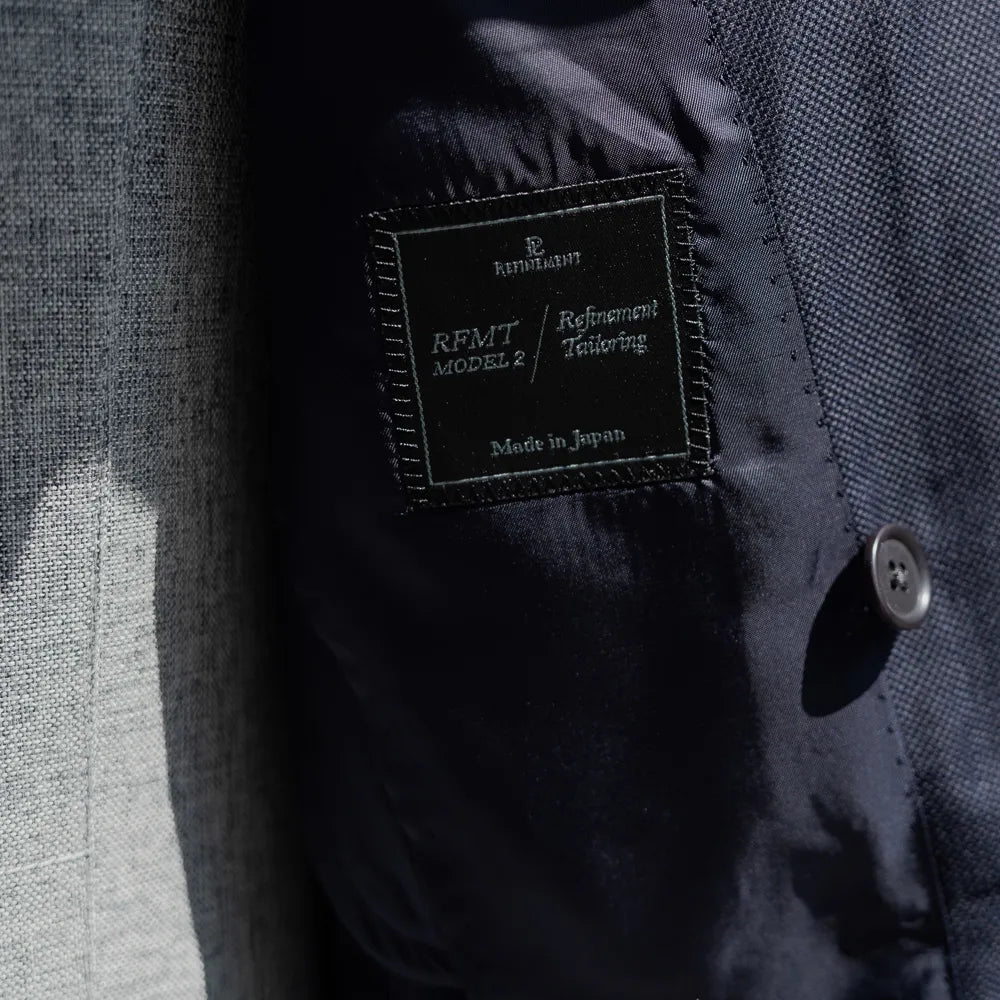 Close-up of the Refinement inner brand label stitched inside the blazer.