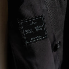 Close-up of the Refinement inner brand label stitched inside the jacket.
