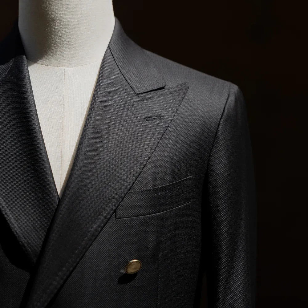 Close-up of the lapel roll and chest pocket showing refined tailoring lines.