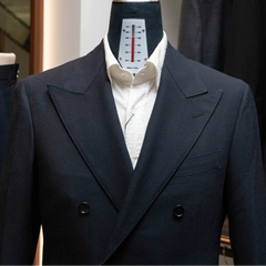 Close-up of the peak lapels showing crisp structure, pick stitching, and the subtle weave of the Woodhead navy wool.