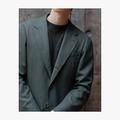 Close-up detail of RMJ-03 green single breasted jacket by Ring Jacket showing VBC fabric texture