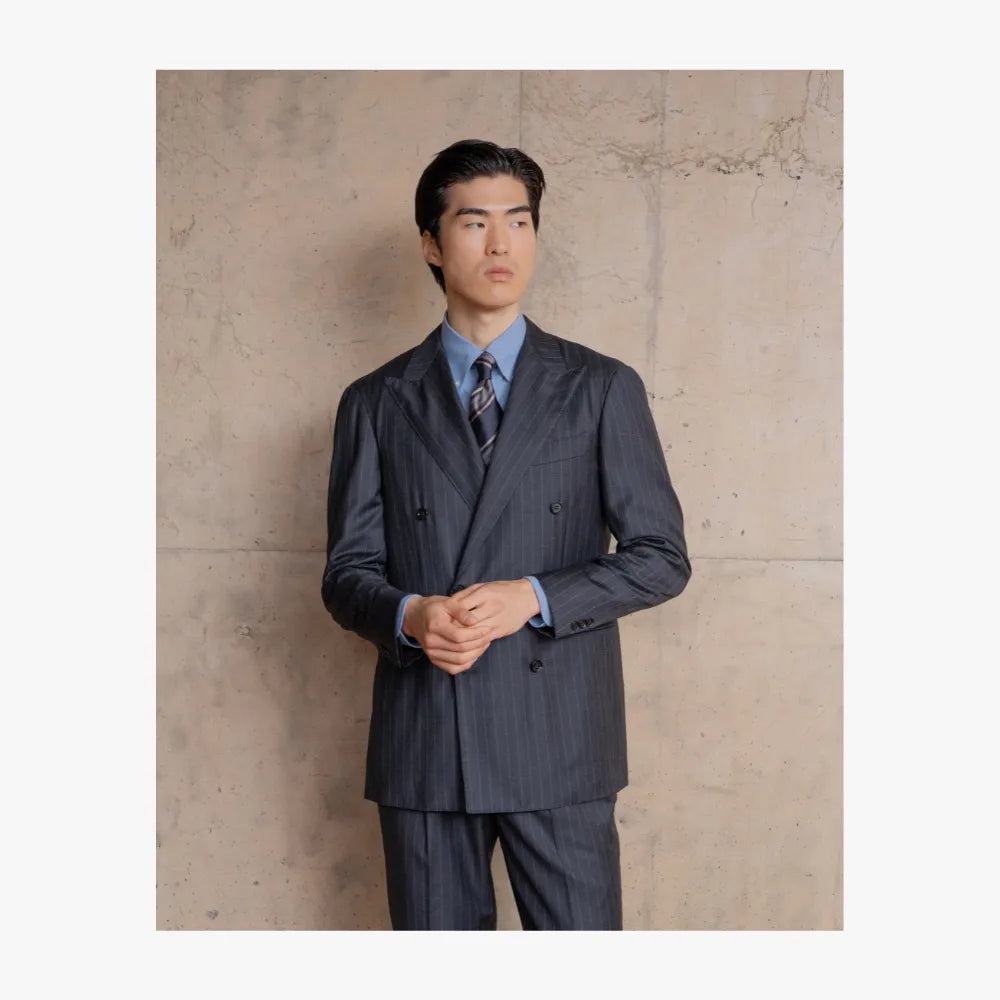 Man wearing RMJ-04 charcoal grey chalkstripe double breasted suit by Ring Jacket in a refined tailored style