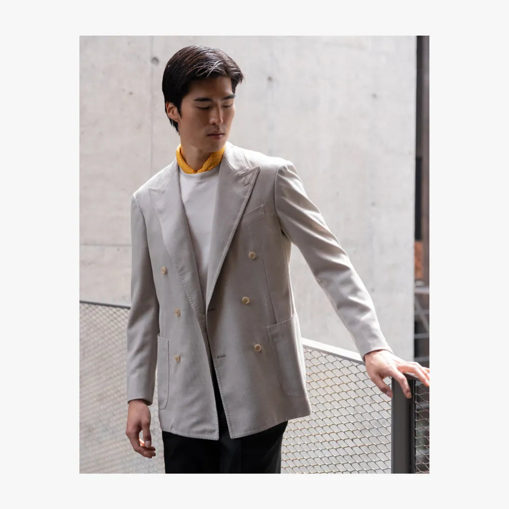 Man wearing RMJ-04 ivory double breasted jacket by Ring Jacket, styled in a refined tailored look