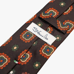 Close-up of the back side of the Stefano Cau floral tie showing the brand label, hand-finished stitching, and clean construction.