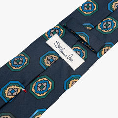 Close-up of the back side of the Stefano Cau floral tie showing the brand label, hand-finished stitching, and clean construction.