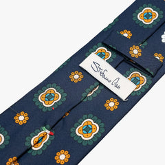 Close-up of the back side of the Stefano Cau floral tie showing the brand label, hand-finished stitching, and clean construction.