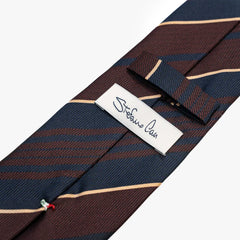 Close-up of the back side of the Stefano Cau regimental tie showing the brand label, hand-finished stitching, and clean construction.