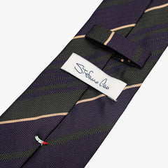 Close-up of the back side of the Stefano Cau regimental tie showing the brand label, hand-finished stitching, and clean construction.