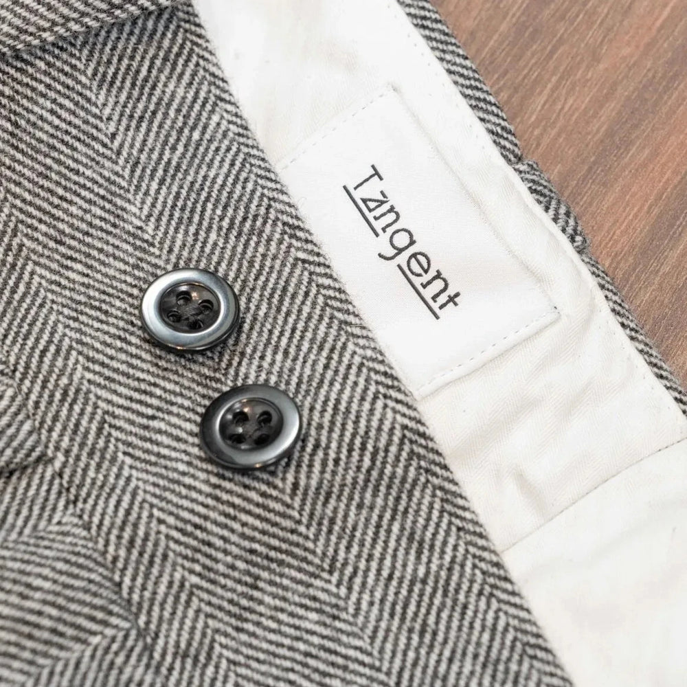 Close-up of the inner label of the Tangent TAN02 Henry Hard Classic Tweed Herringbone Light Grey trousers showcasing branding and construction quality.