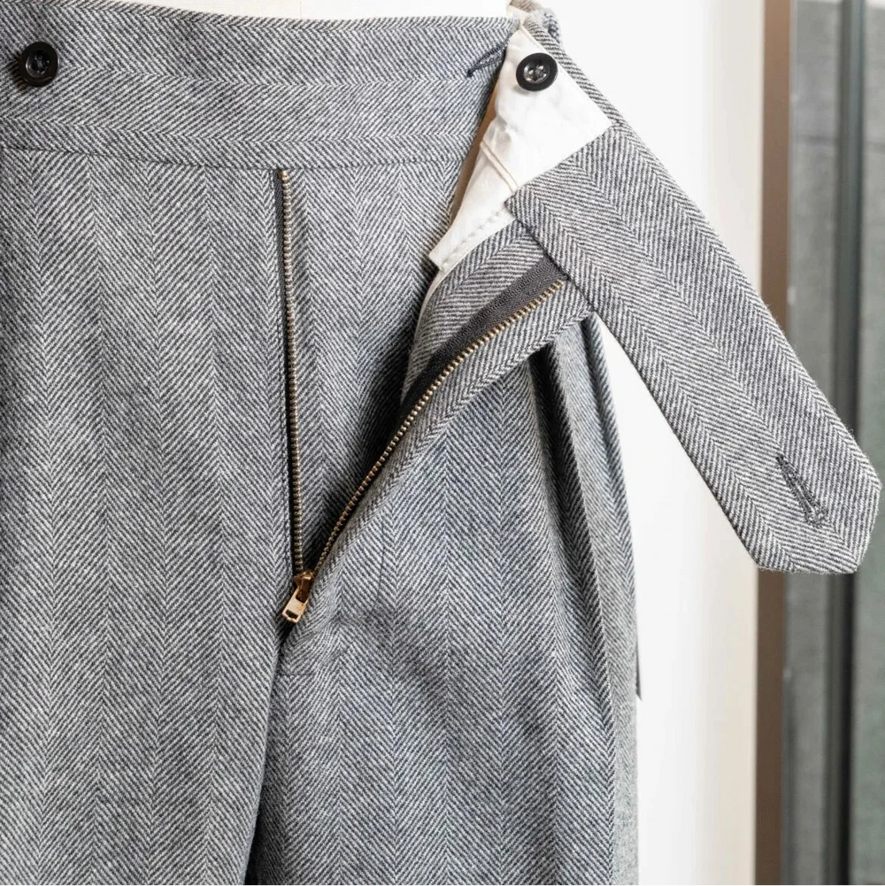 Close-up of the waistband of the Tangent TAN02 Henry Hard Classic Tweed Herringbone Light Grey trousers showing adjusters and button details.