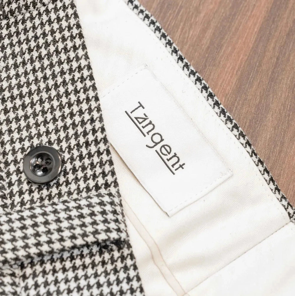 Close-up of the inner label of the Tangent Tan 25° Wool Check Hound Tooth trousers showcasing branding and craftsmanship.