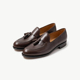 A pair of TLB Mallorca 316 Jones Tassel Loafers in dark brown vegano leather, shown at an angle to highlight the tassel detail and refined shape.
